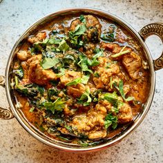 a bowl filled with meat and greens on top of a table