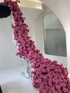 a large bouquet of pink roses on display in a white room