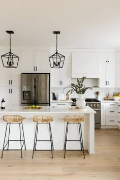 three stools sit at the center of a kitchen island