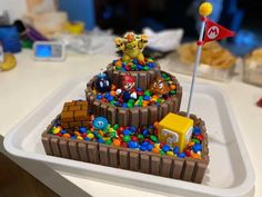 a cake made to look like an island with mario and luigi in it on a white plate