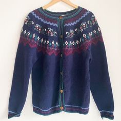 "This vintage Northern Reflections cardigan is a one-of-a-kind piece that will add a touch of unique style to your wardrobe.  The beautiful blue and green colors, combined with the 3D floral embroidery, make this cardigan perfect for any casual occasion.  The wool and cotton materials provide both comfort and durability.   This cardigan is a true original from the 1990s, made in Hong Kong with high attention to detail.  The size is a women's L and it has a secretary/geek look that will make you Embroidered Blue Sweater For Fall, Blue Embroidered Sweater For Fall, Blue Embroidered Winter Sweater, Blue Fair Isle Pattern Outerwear For Fall, Blue Fair Isle Pattern Fall Outerwear, Blue Fair Isle Outerwear For Fall, Retro Blue Cardigan For Winter, Vintage Knitted Blue Outerwear, Vintage Blue Knitted Outerwear