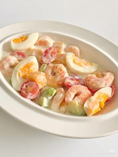 a white bowl filled with shrimp salad on top of a table