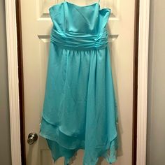 a blue dress hanging on a door