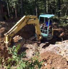 an excavator digs through the ground to clear up debris