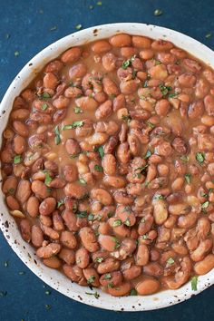 a white bowl filled with beans on top of a blue table