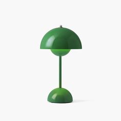 a green table lamp sitting on top of a white surface