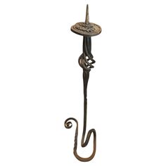 an iron hook with a decorative design on the end and a metal umbrella holder attached to it