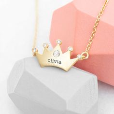 For a fabulous gift that'd be perfect for a princess of any age, she's bound to love our super-cute personalised kids princess crown necklace. She's bound to love and show off her beautiful new necklace to her friends, its elegant craftsmanship and gorgeous design are guaranteed to impress her queendom. This stylish necklace will make a wonderfully sentimental birthday gift for your little princess or a fabulous Christmas present for that future queen in your life.   Each point of your loved one's crown-design necklace is encrusted with a small crystal, with a slightly large crystal placed prominently in a central position on the crown.   Personalise your loved one's necklace with their name for a gift that is as unique as they are. Our dedicated team of artisan creatives will then meticul Adjustable Crown Design Jewelry For Gift, Adjustable Crown Design Jewelry As Gift, Princess Style Jewelry With Crown Design, Personalized Princess Style Jewelry For Gifts, Personalized Princess Style Jewelry Gift, Princess Style Gold Jewelry Gift, Crown Design Jewelry For Valentine's Day Gift, Gold Princess Style Jewelry For Gift, Princess Style Gold Jewelry For Gifts