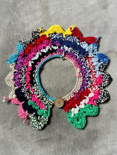 a multicolored crocheted collar is on the ground