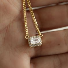 "Beautiful necklace featuring an emerald cut stone with a pavé halo. It's absolutely stunning, and will become your new favorite piece! Great for everyday, as well as special occasions!  - - - D E T A I L S - - - * Made of 925 Sterling Silver * We use a THICK plating of 14k Gold or Rhodium for a piece that will last you years to come!  * 16\", 18\", 20\" + 3\" extension chain  * 4x6mm Center Stone * 2mm Cuban Link Chain * We use the highest grade of CZ's for an authentic diamond look! * Nickel-free & Hypoallergenic  ▶︎▷▶︎ Necklaces on Model Tag Necklace - https://www.etsy.com/listing/1584467295/custom-dog-tag-necklace-name-necklace?click_key=2ca50203fb543f68086781e07d07c154965d40c3%3A1584467295&click_sum=37b91579&ga_search_query=custom%2Btag&ref=shop_items_search_2&pro=1&frs=1 Tiny Square Emerald Cut Necklace, Hypoallergenic Necklace, Baguette Necklace, Necklace Emerald, Sparkly Necklace, Chain Making, Chunky Earrings, Chic Necklace, Dainty Gold Necklace