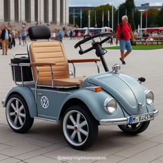 an old style car is parked in front of a building with people walking around it