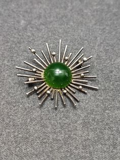 Vintage Mid Century sputnik  Brooch  with green gemstone  70s Silver mark : 925 and makers mark Ø  5 cm (2")  in good vintage condition - no chips, cracks or any other damage All items will be securely wrapped and boxed for shipment Please see pictures for condition and don't hesitate to ask questions. Browse through http://www.etsy.com/shop/retromungo for more vintage, retro and mid century items!! Mid-century Green Brooch For Formal Occasions, Mid-century Green Brooches For Formal Occasions, Green Mid-century Style Brooches For Formal Occasions, Mid-century Green Formal Brooches, Mid-century Green Collectible Jewelry, Mid-century Green Brooch As A Gift, Retro Green Brooch Jewelry, Green Round Brooch For Formal Occasions, Vintage Brooch