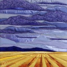 a quilted landscape with mountains and fields in the foreground, blue sky above