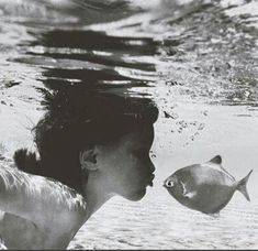 a woman is kissing a fish under the water