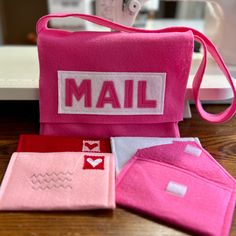 a pink bag with the word mail on it sitting next to some other items and a sewing machine