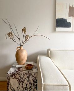 a living room with a couch, table and vase