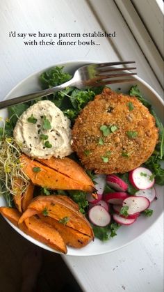 a white plate topped with carrots, meat and veggies next to a fork