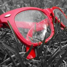 a pair of red glasses laying in the grass