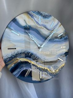 a hand holding a clock with blue and white designs on it