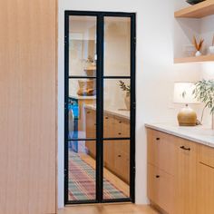 a kitchen with wooden cabinets and black glass doors on the door way to the dining room