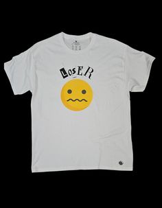 Make a bold statement with this graphic t-shirt featuring a distressed "Loser" text above a confused smiley face. The striking design contrasts the playful emoji with the edgy typography, creating a unique blend of humor and street style. This tee is perfect for anyone who enjoys quirky, offbeat fashion and isn't afraid to stand out. **Key Features - **Design Confused smiley face with distressed "Loser" text - **Color White or choose your color. - **Fit True to size - **Style Alternative streetwear with a playful twist - **Perfect For Fans of quirky designs, bold fashion statements, and casual streetwear This t-shirt is perfect for adding a bit of personality to your wardrobe. Whether you're embracing your inner "loser" or just love unique graphic tees, this is a must-have for your collect Cheap Novelty T-shirt With Text Print, Affordable Pop Culture T-shirt With Text Print, Offbeat Fashion, Edgy Typography, Smiley Face Tshirt, Edgy Streetwear, Quirky Design, Style Streetwear, Casual Streetwear