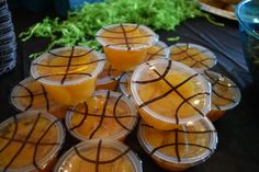 plastic cups filled with orange juice sitting on top of a table