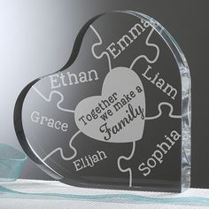 a heart shaped glass award with words on it and a ribbon in the corner next to it