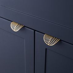 a close up view of the handles on a blue cabinet with gold leaf knobs