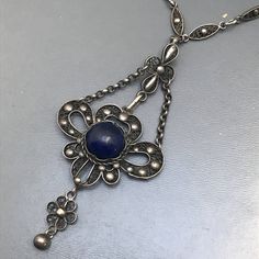 Fine Vintage Art nouveau / Art deco silver filigree pendant necklace ~ Pendant has a central bezel set blue lapis stone set on an filigree base ~ which is attched to a fine filigree chain . Clasp is Marked DRGM / Deutsches Reich Geschmacksmuster for German patent mark . Necklace is acid tested for silver Measurements : Necklace is 20 inches in length x 3/8 inches max chain width .Pendant adds 3 inches in total drop length x 1 1/4 inches max width Weighs 16 grams on my weighing scale . Condition: Antique White Gold Filigree Necklace, Antique White Gold Necklace With Filigree, Art Nouveau Pendant Jewelry With Intricate Design, Silver Filigree Art Nouveau Necklace, Silver Oval Art Deco Necklace, Silver Necklace With Intricate Art Nouveau Design, Art Nouveau Silver Filigree Necklace, Art Nouveau Necklace With Intricate Design For Gift, Victorian Silver Necklace With Cabochon