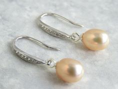 Beautiful 925 sterling silver dangle hook earring, UK Hallmark 8x9mm peach freshwater pearls with very good lustre on 925 Sterling silver hooks with cubic zirconia setting.  The earrings is approximately 2.7cm long The pearls are genuine freshwater pearls therefore each pearl is slightly different in shape and size and has its own unique blemishes. These earrings are made to order, therefore the earrings you receive maybe slightly different to the one in photo. The colour of the actual earrings Elegant Apricot Earrings For Gift, Elegant Apricot Dangle Earrings, Elegant Apricot Dangle Jewelry, Elegant Apricot Jewelry For Wedding, Dangle Earrings Wedding, Freshwater Pearls Earrings, Wedding Jewelry Earrings, Drop Dangle Earrings, Earrings Wedding