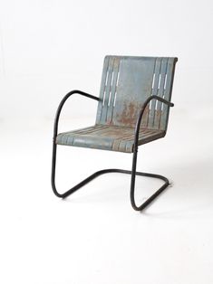 an old metal chair sitting on top of a white floor