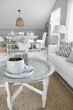 a living room filled with white furniture and decor