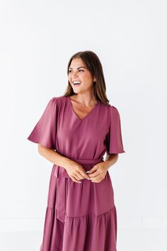 Features V neckline Short flutter sleeves Tie waist Dark mauve color with cream embroidered hem Pockets Dress & Lining: 100% Polyester Size + Fit Small 0-4, Medium 4-8, Large 8-12, X-Large 12-16 Kristin is 5'4", a size 1 and is wearing a Small Runs true to size. Measurements taken while laying flat and then doubled. They do no account for stretch. Click here for shoes shown in photos Size Bra Band Length Small 36" 46" Medium 38" 47" Large 40" 47" X-Large 42" 48" Purple V-neck Dress With Ruffle Hem, Chic Mauve Short Sleeve Dress, Solid Bell Sleeve Dresses For Spring, Spring Solid Color Dress With Bell Sleeves, Spring Solid Color Bell Sleeve Dress, Flowy Mauve V-neck Dress, Mauve Short Sleeve Dress For Spring, Short Sleeve Mauve Dresses For Spring, Modest V-neck Dress With Ruffle Hem