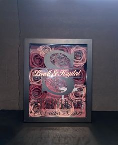 the wedding sign is made out of pink roses and has a silver number 8 on it