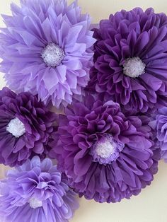 purple flowers are arranged on a white surface