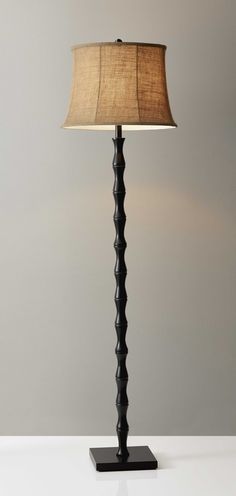 Add a bright anchor to your room with this 62 inch black textured pole floor lamp with beige burlap shade. Classically styled, this traditional lamp features a straight pole that extends upwards from a single base and is weighted and designed to be sturdy and stable. The scalloped body shape and beige burlap shade give this lamp a warm rustic almost tropical vibe. Use this lamp anywhere and elevate the look of the whole space. 62 inch H x 17 inch W x 17 inch D. HomeRoots 62-in Brown and Black Floor Lamp | 4000372478 Den Home Office, Black Metal Floor Lamp, Farmhouse Floor Lamps, Soft Contemporary, Traditional Lamps, Metal Pole, The Den, Updated Traditional, Metal Floor