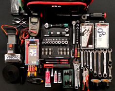 the contents of a tool kit laid out on top of a black surface with tools in it