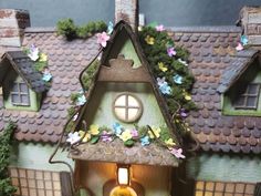 a doll house with flowers on the roof