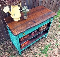 a wooden table with baskets on it and a yellow watering can sitting on top of it