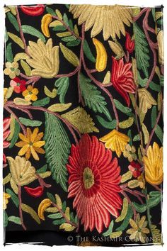 an embroidered black background with red, yellow and green flowers on the left hand side