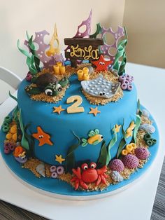 there is a blue cake with under the sea decorations on it