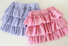 three different colored skirts with ruffles on the bottom and one is blue, pink, and white