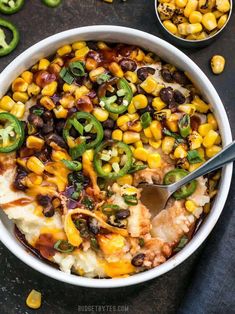 a white bowl filled with corn and black bean casserole on top of a table