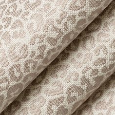 a close up shot of the fabric on a bed sheet that has been made in beige and white lace