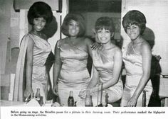 four women in dresses posing for a photo