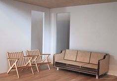 two chairs and a couch in an empty room