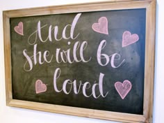 a chalkboard with the words and she will be loved written in pink hearts on it