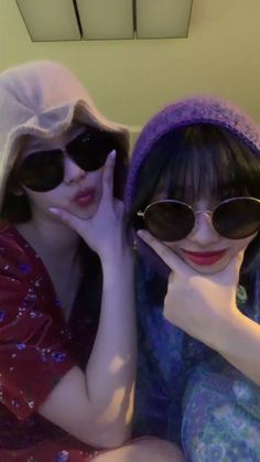 two women wearing sun glasses sitting next to each other