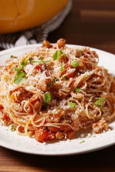 a plate of spaghetti with sauce and parmesan cheese