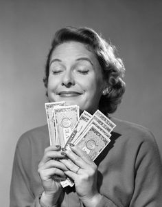 an old photo of a woman holding money